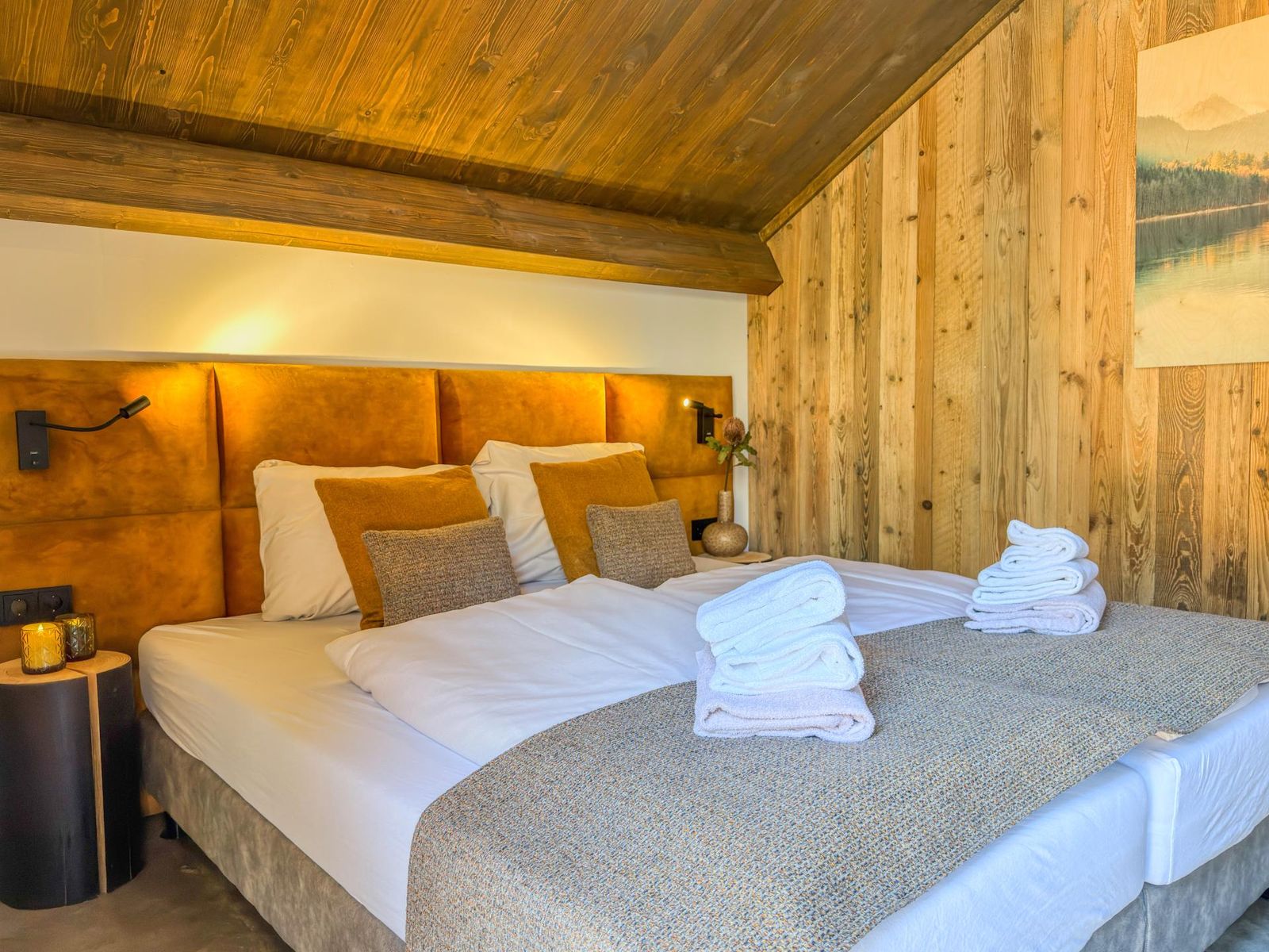 Double bedroom with copper-toned upholstered headboard under a sloped wooden ceiling