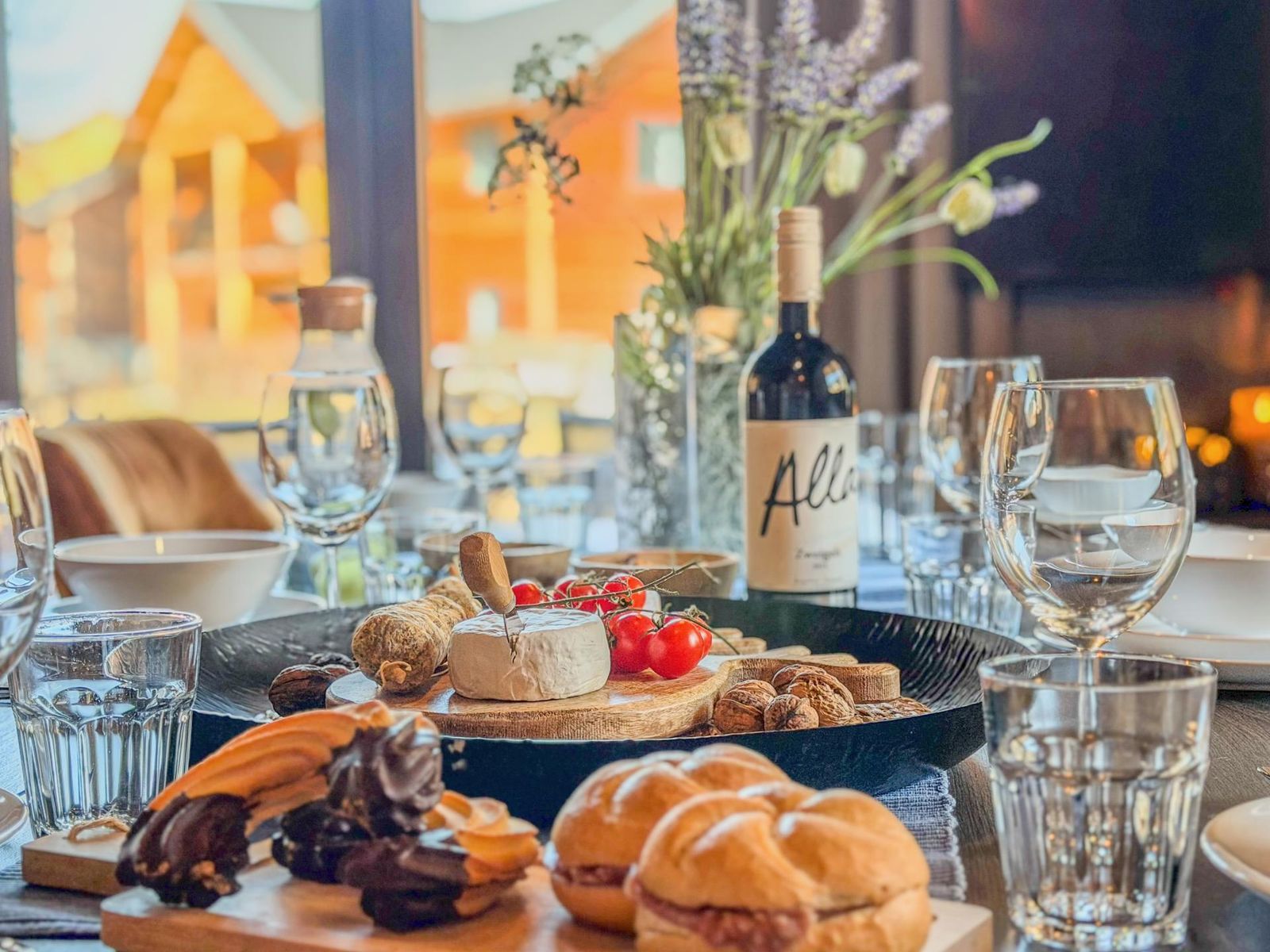 Table with bread, cheese and wine in warm chalet light