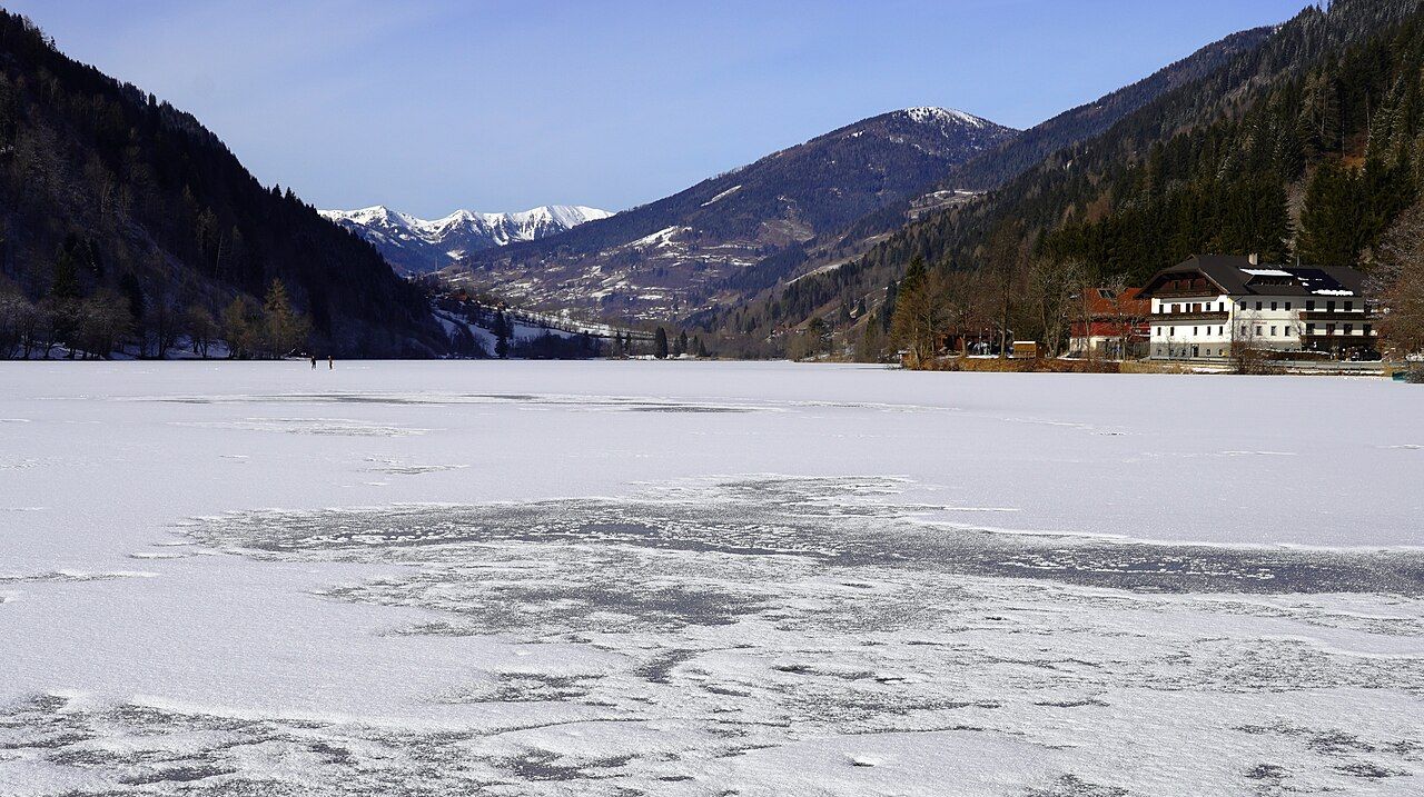 The frozen Afritzer See with snowy Nockberge mountains beyond
